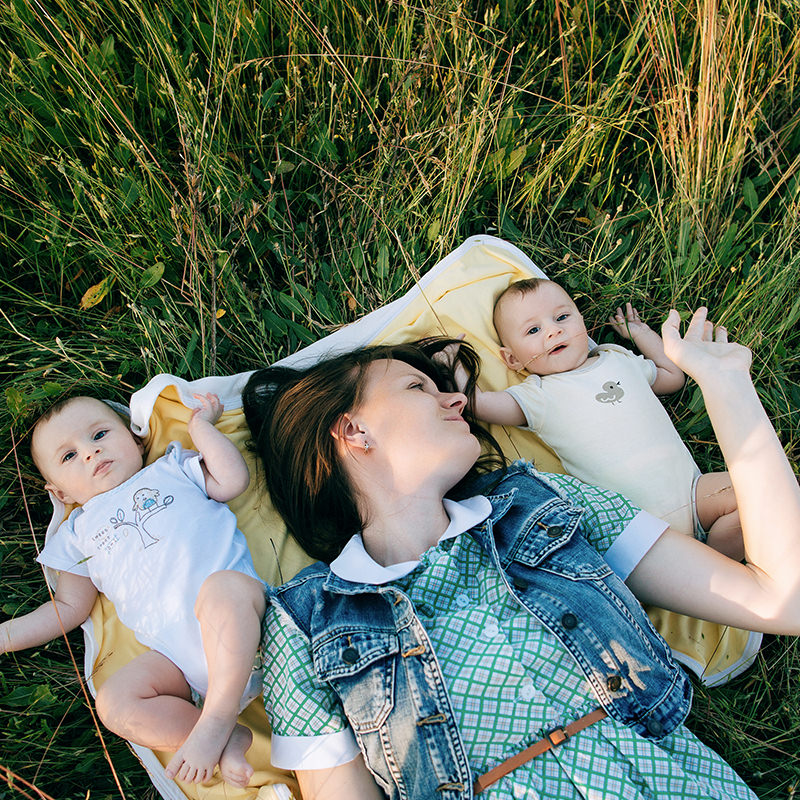 Mother Laying with Babies on a Blanket on the Grass 1 Mother Laying with Babies on a Blanket on the Grass 1