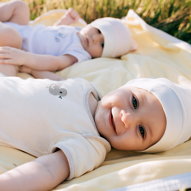 Babies Laying on a Blanket on the Grass Babies Laying on a Blanket on the Grass